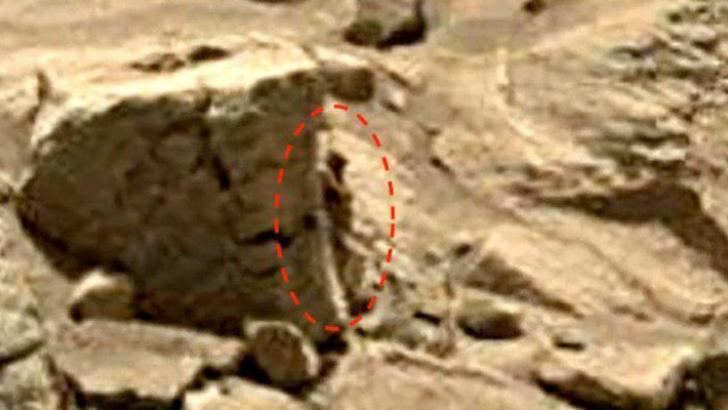 humanoid on Mars leaning on rock